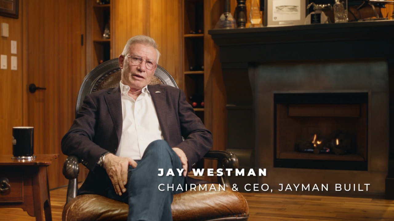Jay Westman seated beside a fireplace. On-screen title: Jay Westman, Chairman & CEO, Jayman BUILT.